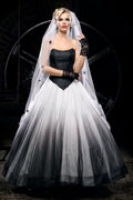 Woman wearing a black and white Victorian wedding dress with a black corset bodice, flowing tulle skirt and long bridal veil, styled as an alternative bride