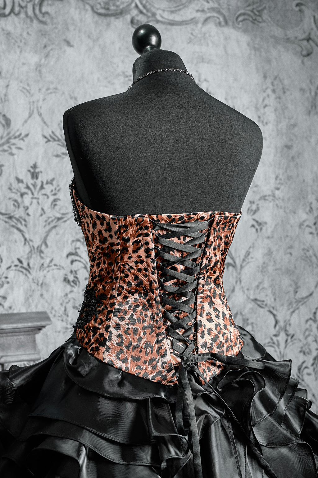 Black Victorian inspired gown with a leopard pattern corset, layered ruffle skirt and dark vampire aesthetic design