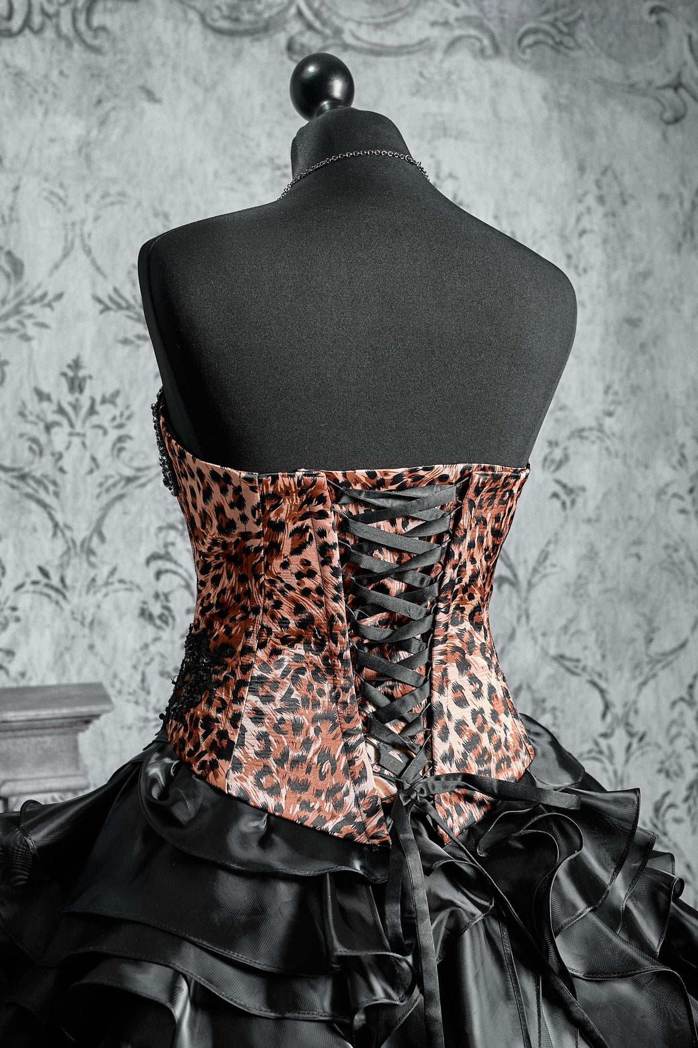 Black Victorian inspired gown with a leopard pattern corset, layered ruffle skirt and dark vampire aesthetic design
