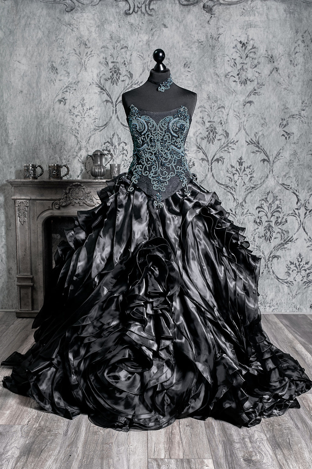 Black Victorian dress featuring a dramatic cascading skirt and an ornate blue beaded corset bodice, combining gothic elegance with alternative wedding fashion