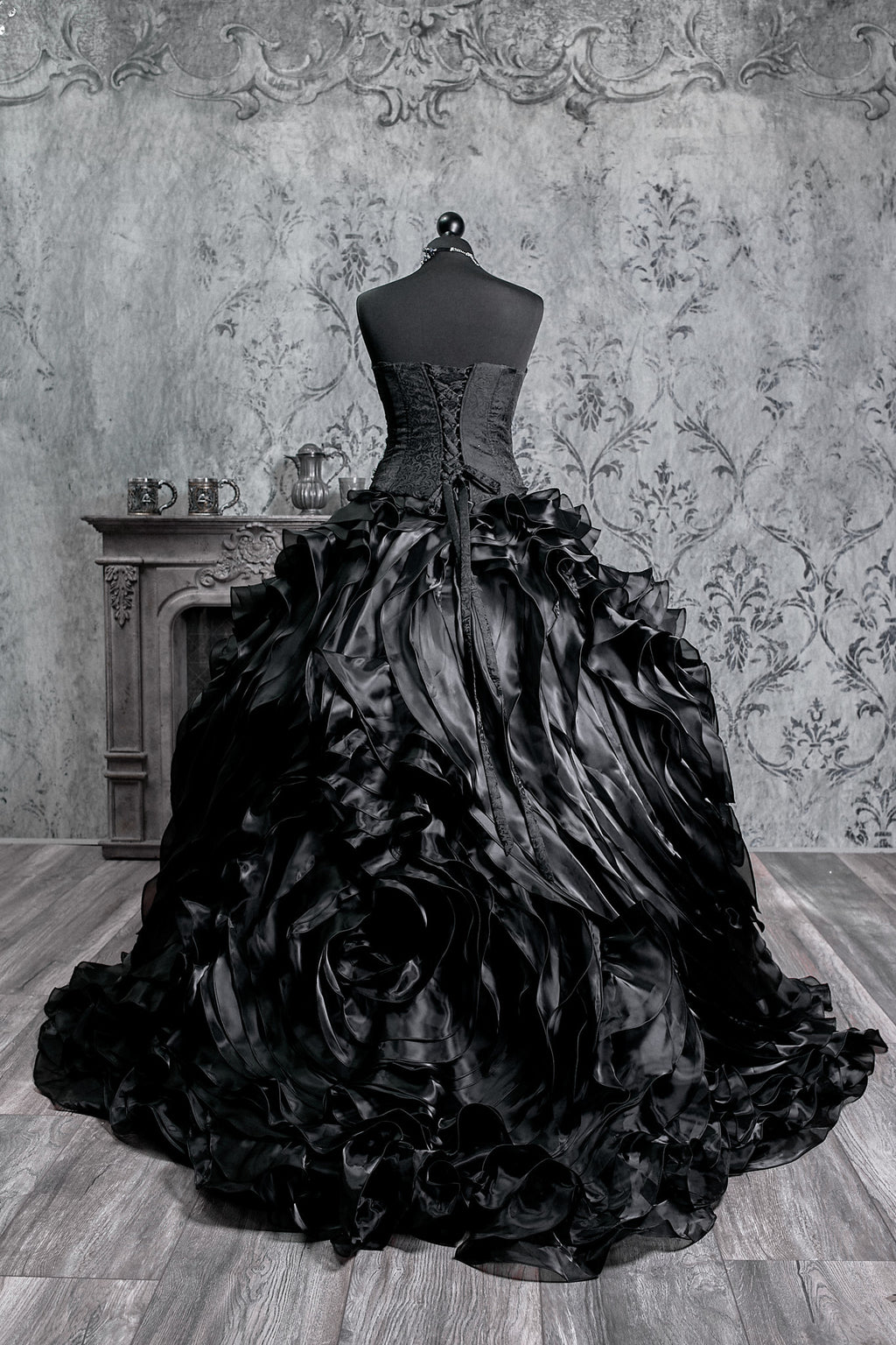 Black Victorian dress featuring a dramatic layered skirt and an ornate red beaded corset bodice, blending gothic elegance with alternative bridal fashion