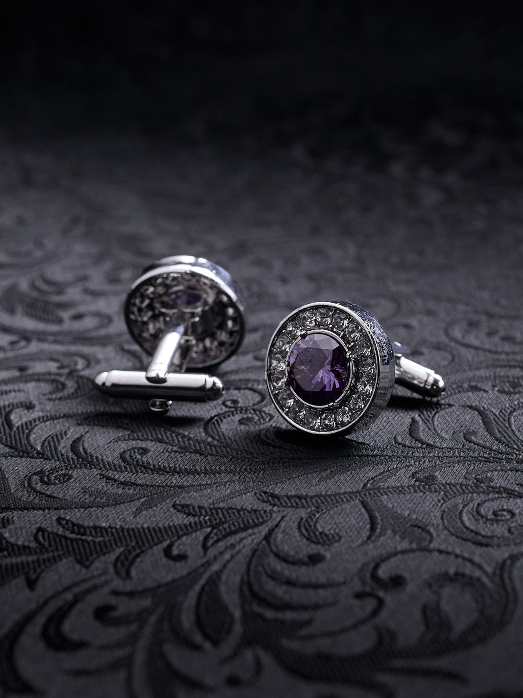 Imperial Violet cufflinks featuring a large central purple crystal surrounded by a halo of small white stones on a dark background.