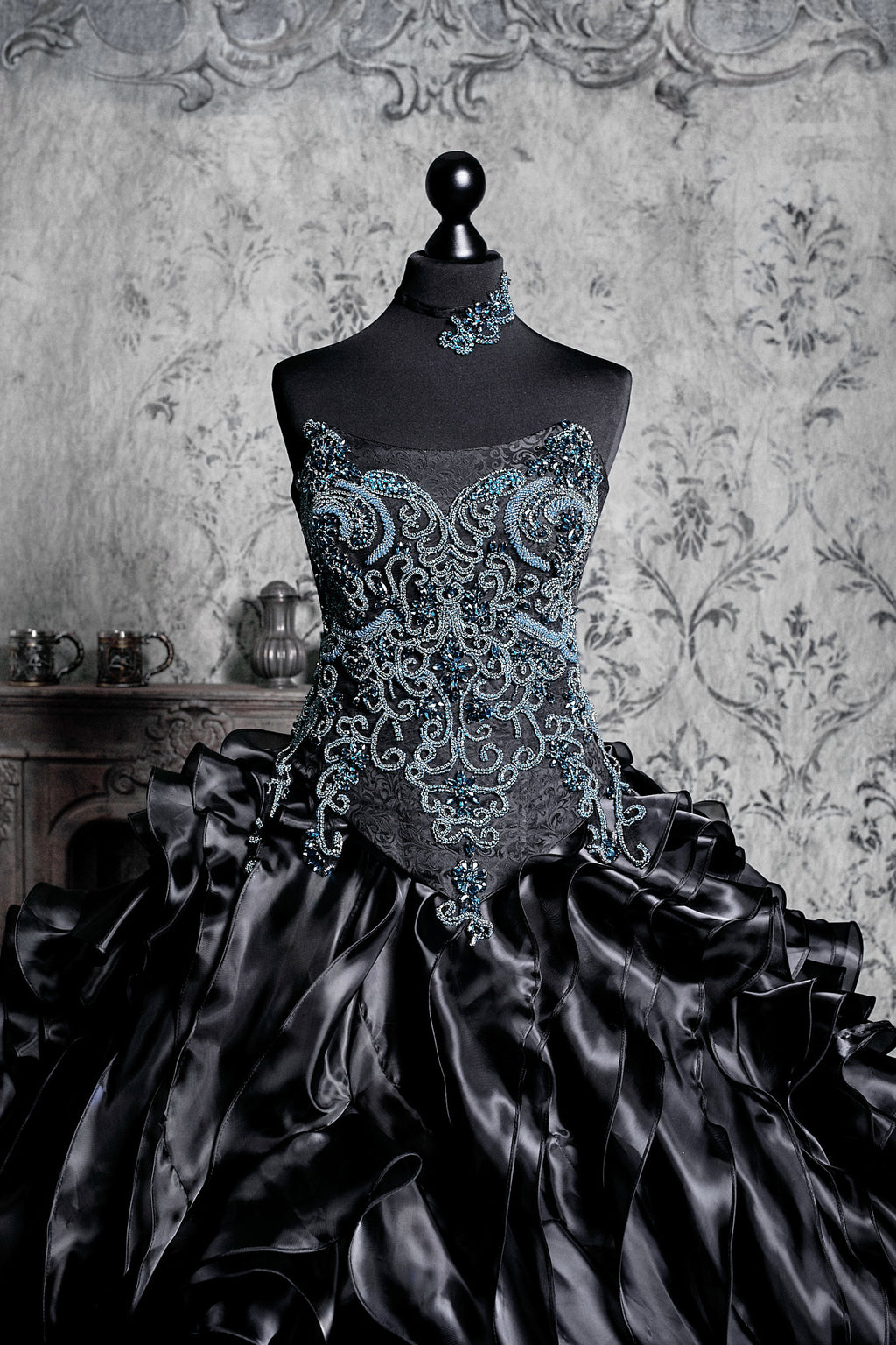 Corset gown adorned with intricate blue embroidery and sparkling embellishments, paired with a voluminous black skirt inspired by Victorian dress design