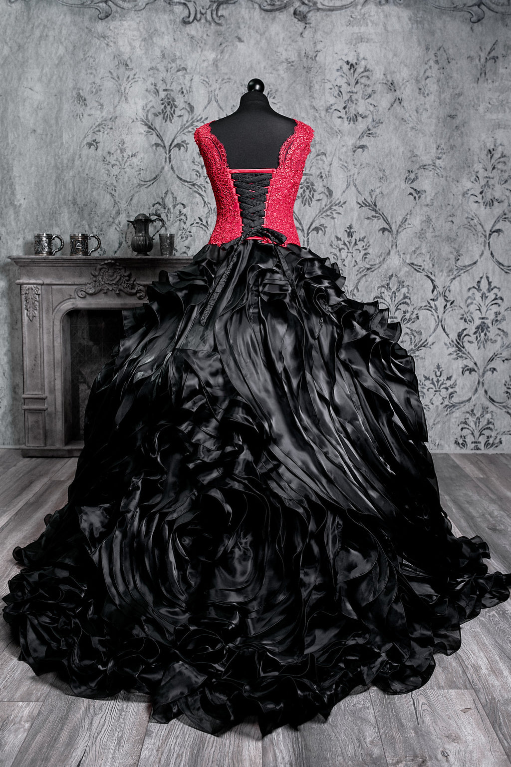Statement Victorian gown featuring a vivid red fitted corset, cascading black fabric layers and a bold vampire aesthetic design