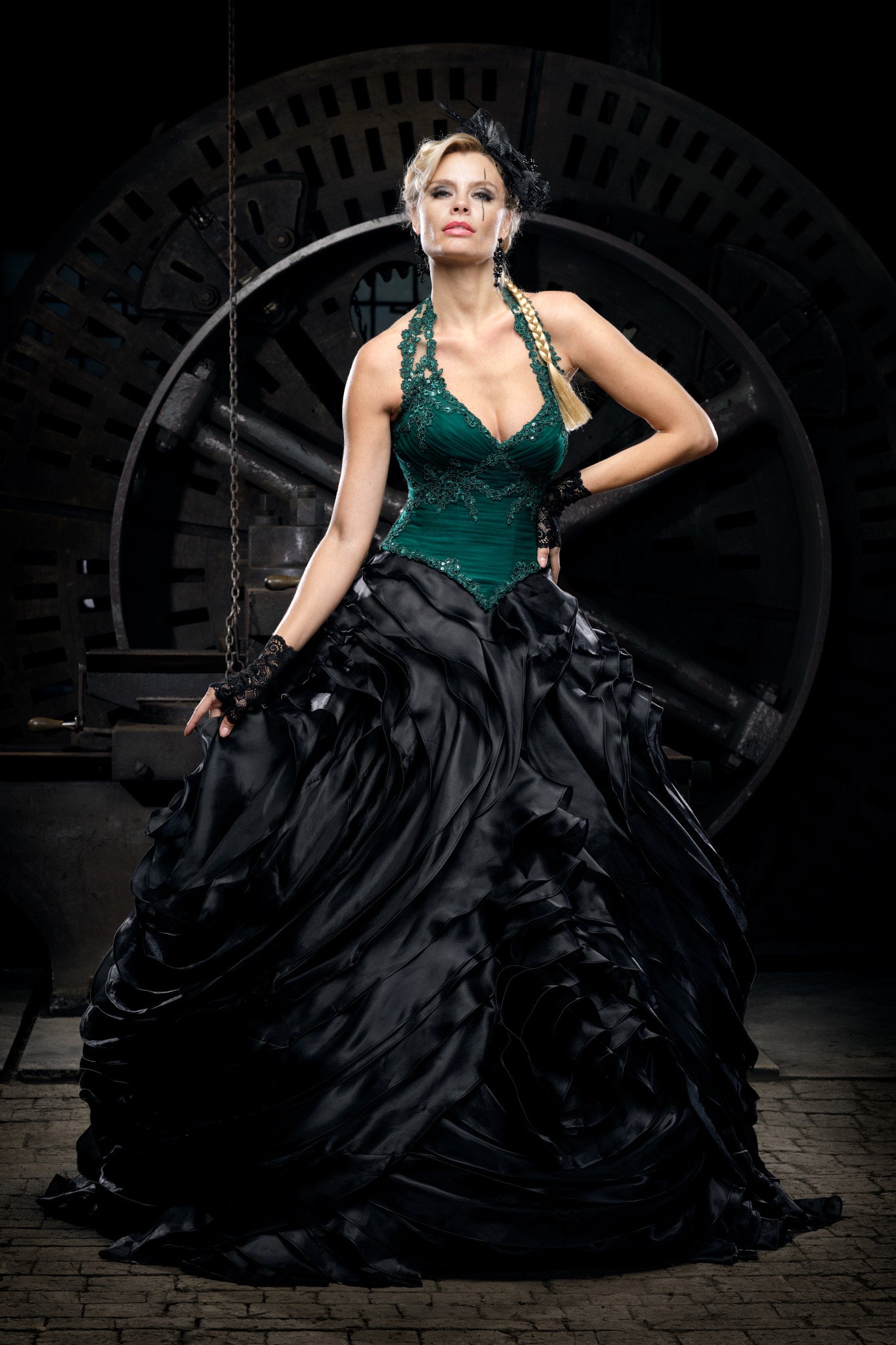 Woman wearing an emerald green corset gown with a dramatic black skirt, Victorian dress inspired alternative bride look in a steam punk setting