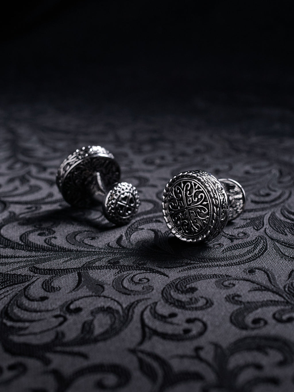 Close-up of the engraved filigree details on Baroque Crest cufflinks, showing the dark oxidized metal texture