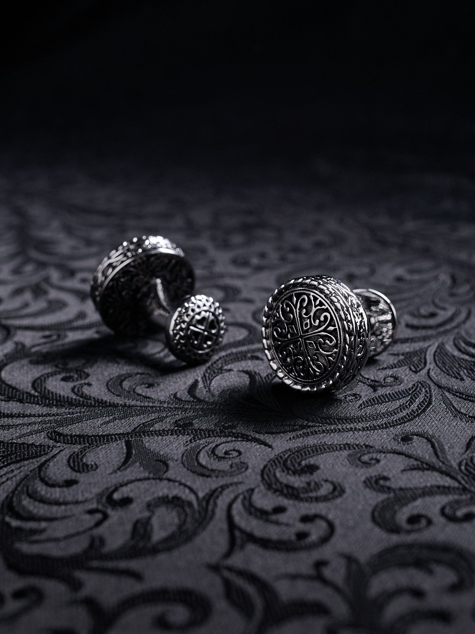 Close-up of the engraved filigree details on Baroque Crest cufflinks, showing the dark oxidized metal texture