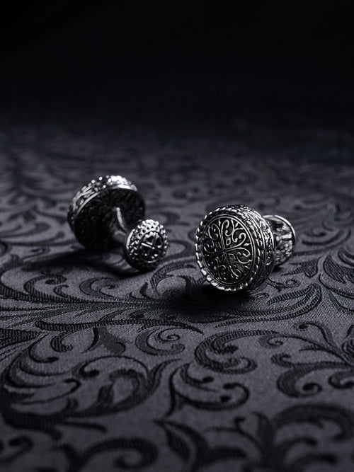 Close-up of the engraved filigree details on Baroque Crest cufflinks, showing the dark oxidized metal texture