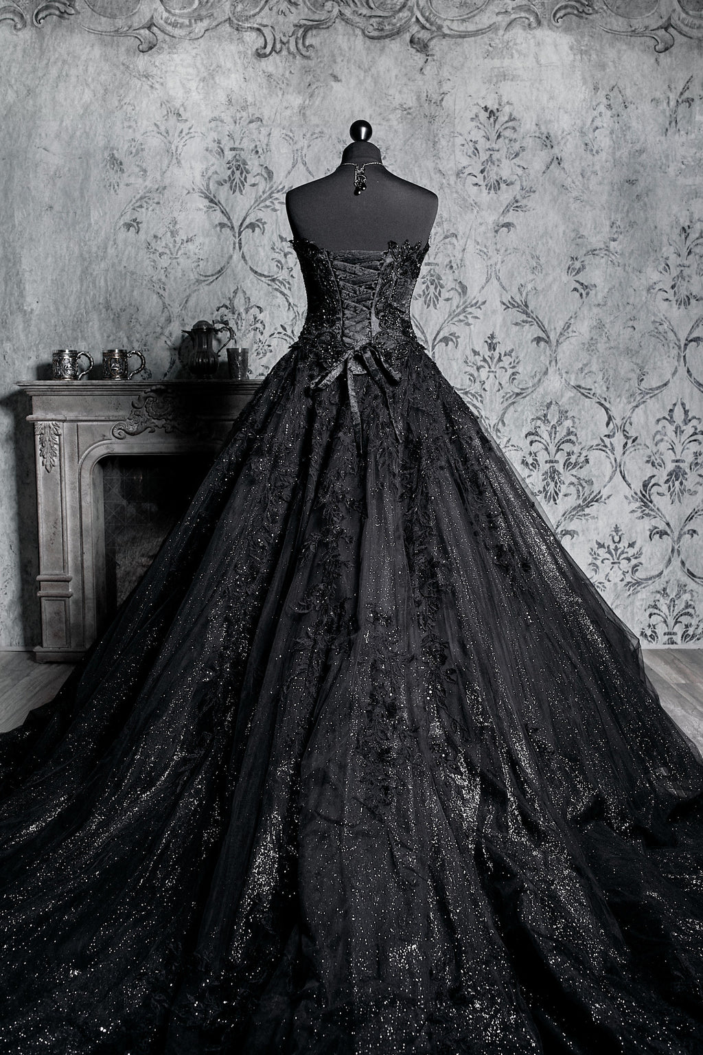 Back view of black gothic ballgown with full lace-up corset ribbon back, glitter tulle skirt with lace overlay and sweeping bridal train