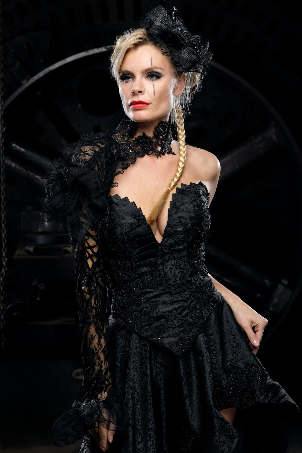 Close-up of deep V gothic corset neckline with scalloped black lace trim edge, structured pleated panels and beaded lace appliqué detailing at waist seam