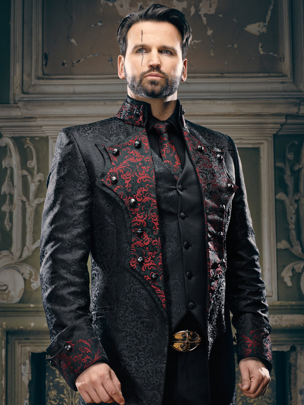Men's black and red gothic frock coat with baroque scroll brocade lapel panels, black skull buttons, matching red brocade tie and ornate heraldic belt buckle