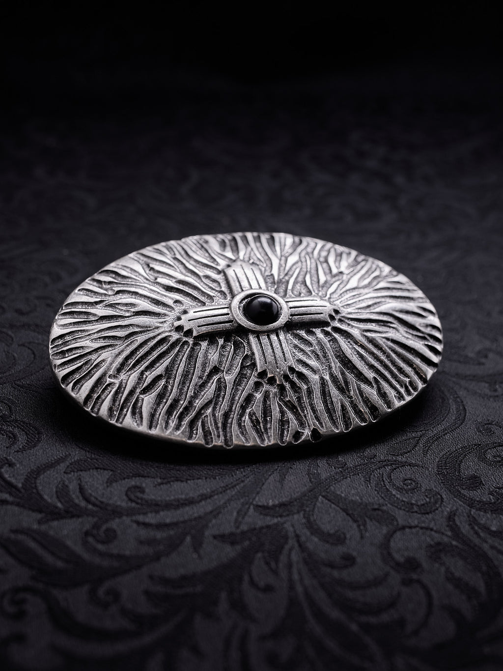 Angled view of the Black Halo metal buckle, showing the depth of the engraved patterns and the antique oxidized effect