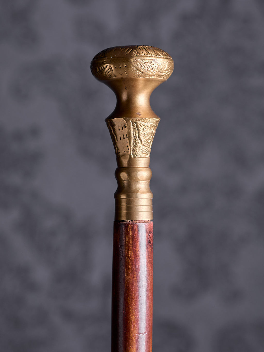 Detailed close-up of the Royal Classic cane handle, highlighting the intricate floral engravings and the warm metallic finish