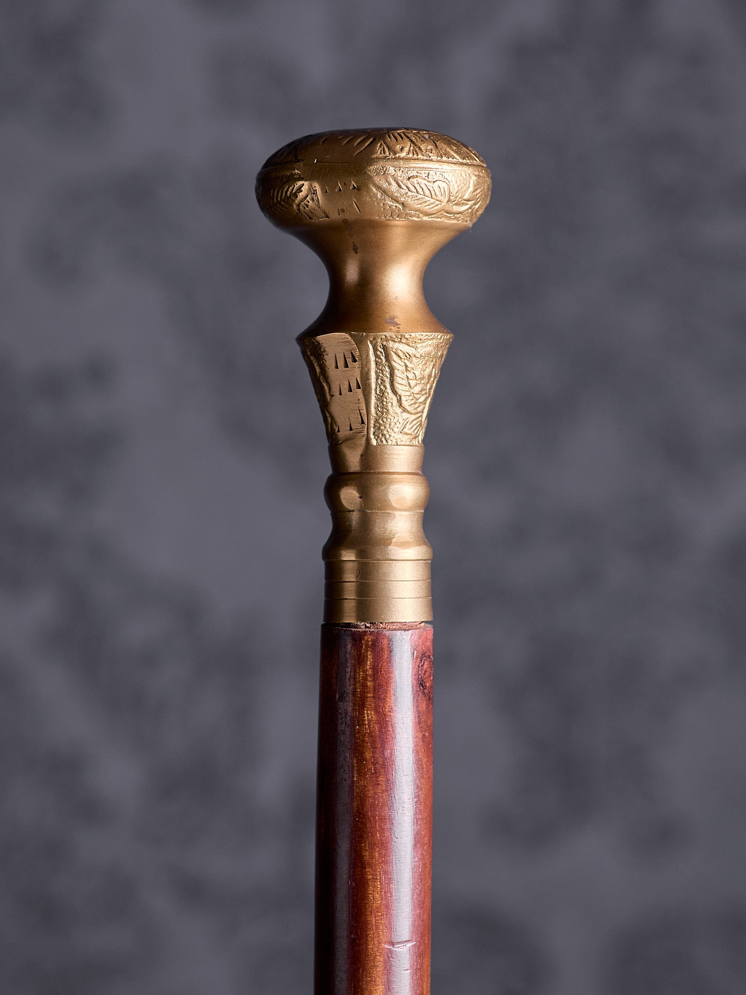 Detailed close-up of the Royal Classic cane handle, highlighting the intricate floral engravings and the warm metallic finish
