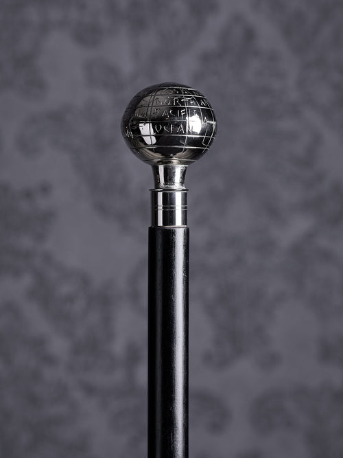 Detailed close-up of the Atlas cane handle, highlighting the engraved names of oceans and geographical lines on the silver sphere