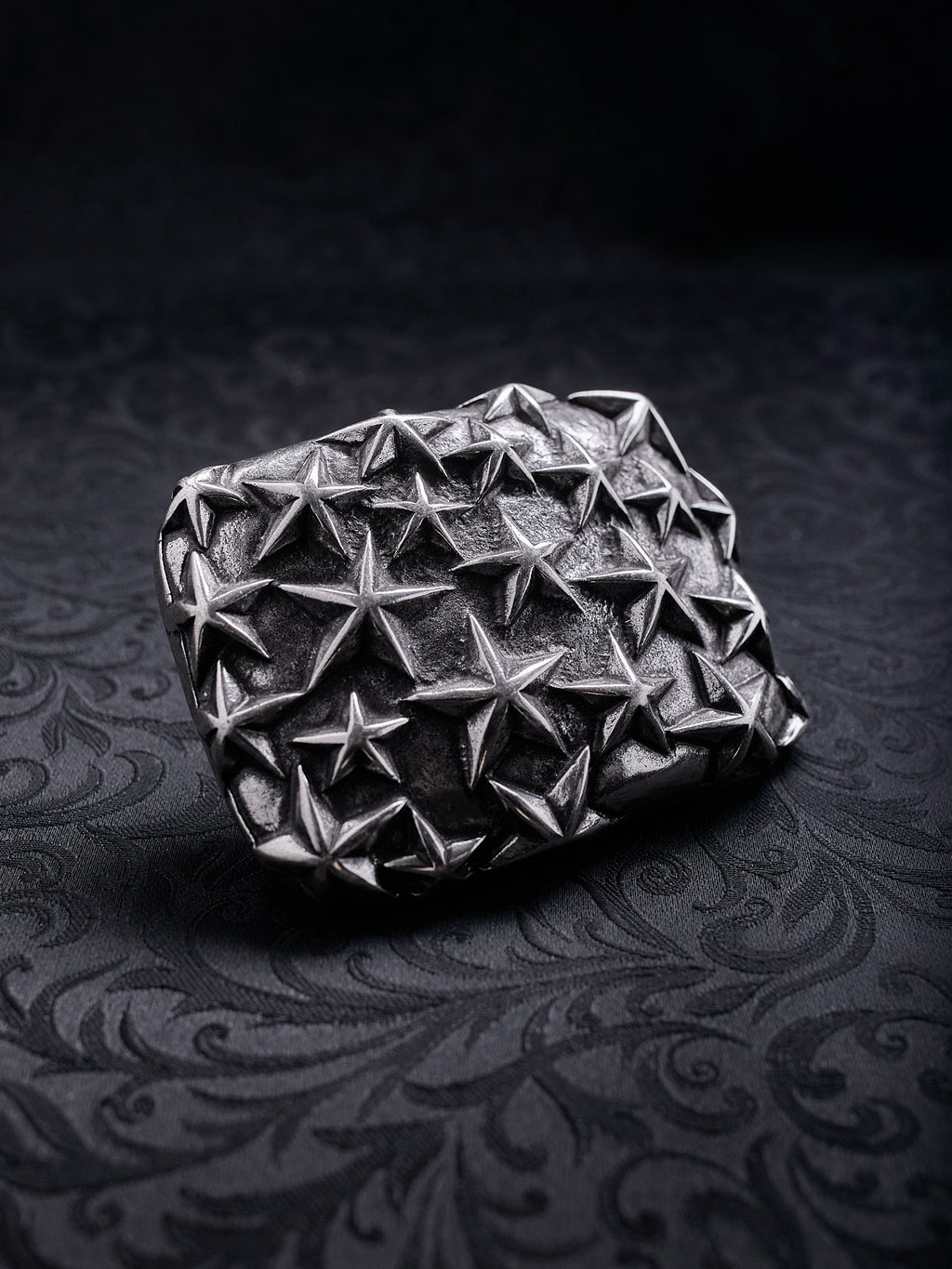 Detailed close-up showing the tactile, rough texture of the metal and the multi-dimensional stars on the Fallen Constellation buckle