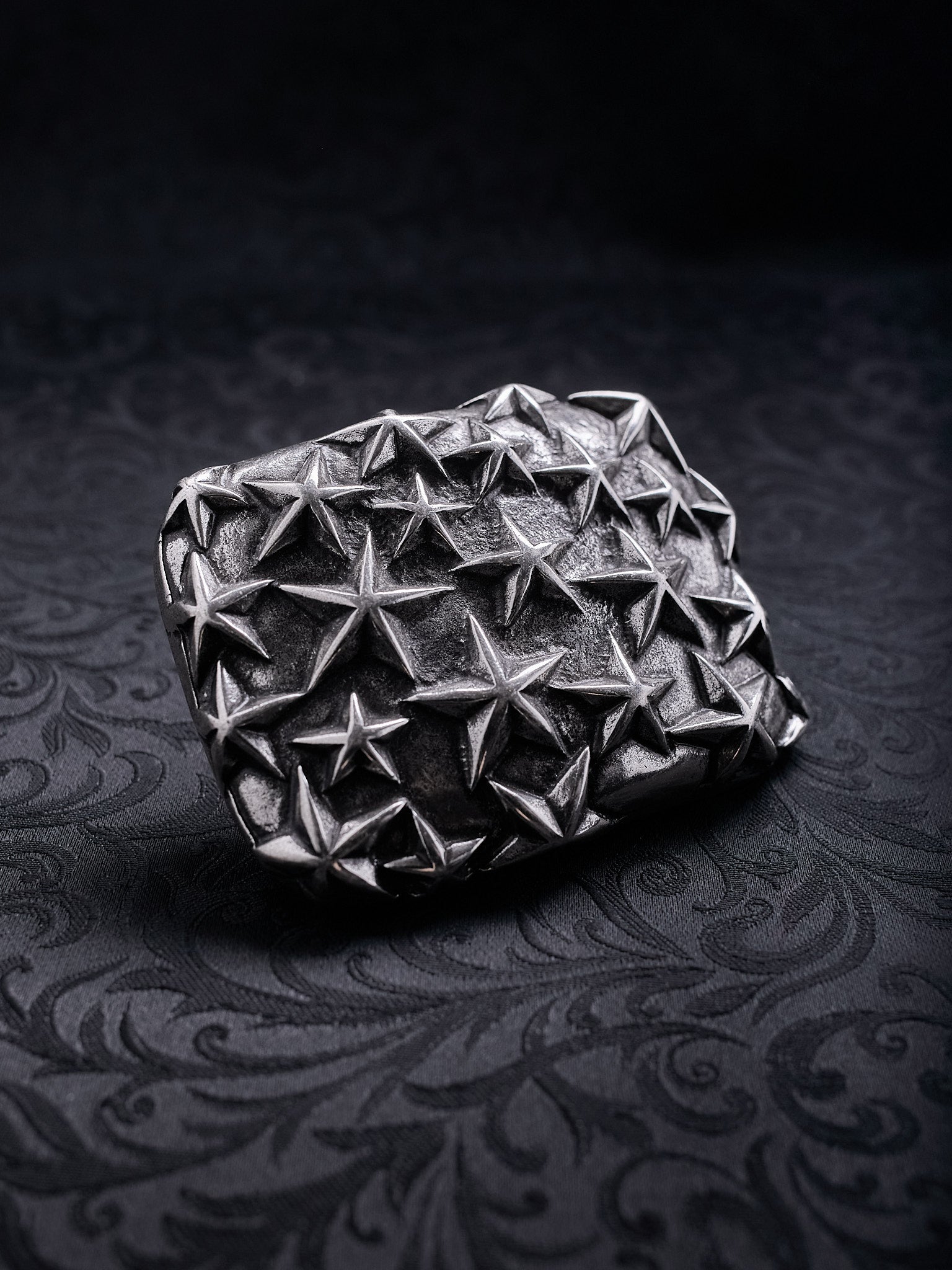 Detailed close-up showing the tactile, rough texture of the metal and the multi-dimensional stars on the Fallen Constellation buckle