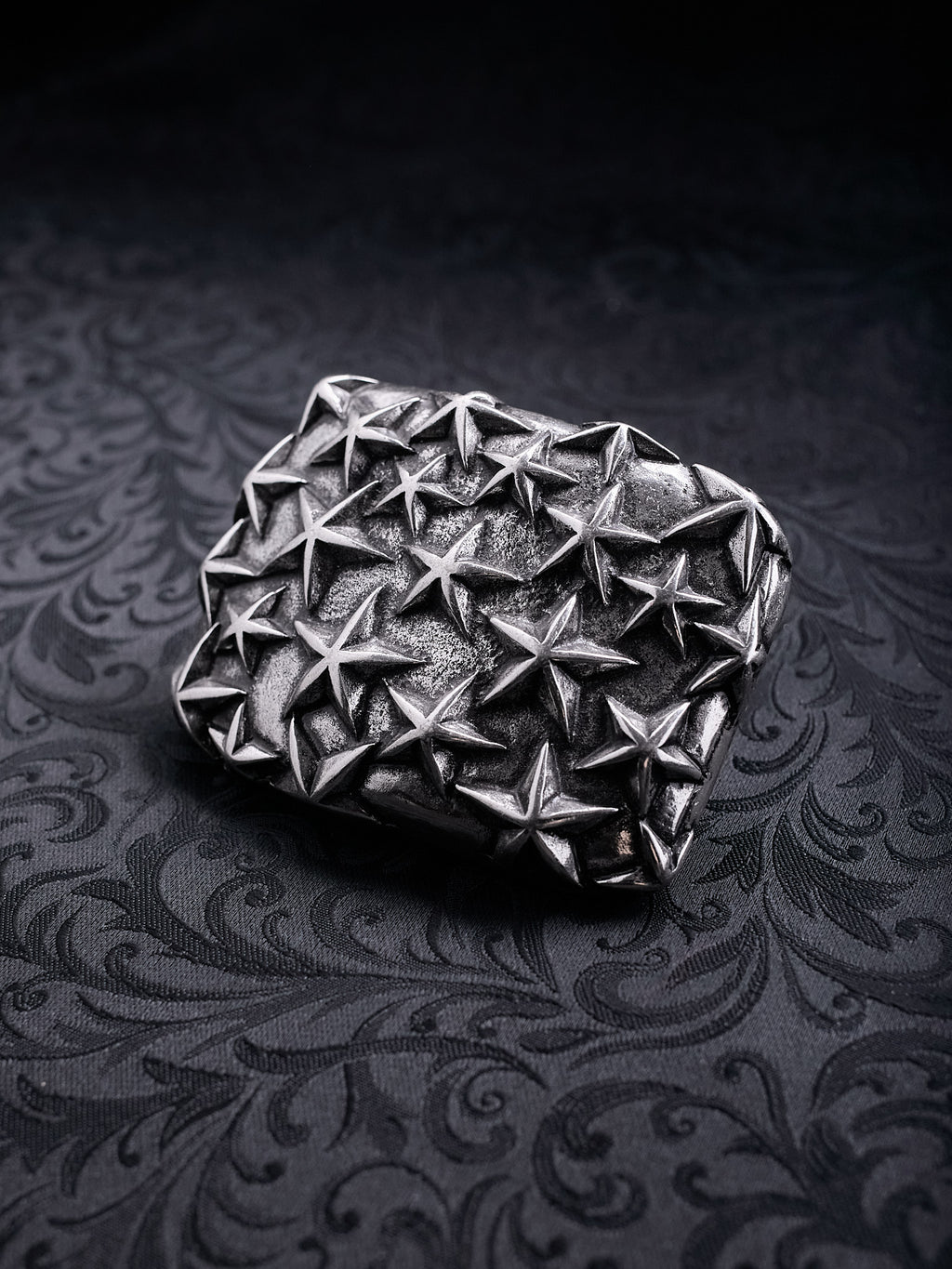 Rectangular metal belt buckle named Fallen Constellation with a dense pattern of raised 3D stars