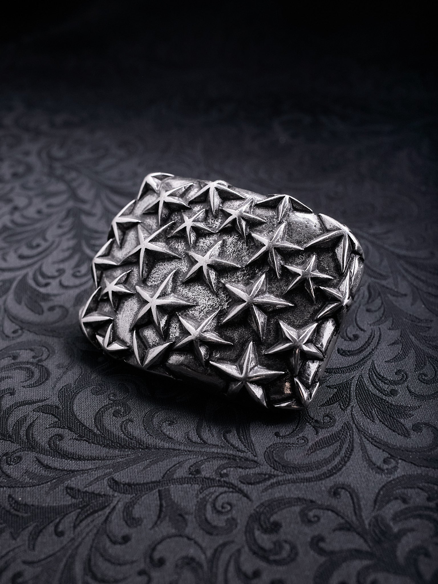 Rectangular metal belt buckle named Fallen Constellation with a dense pattern of raised 3D stars