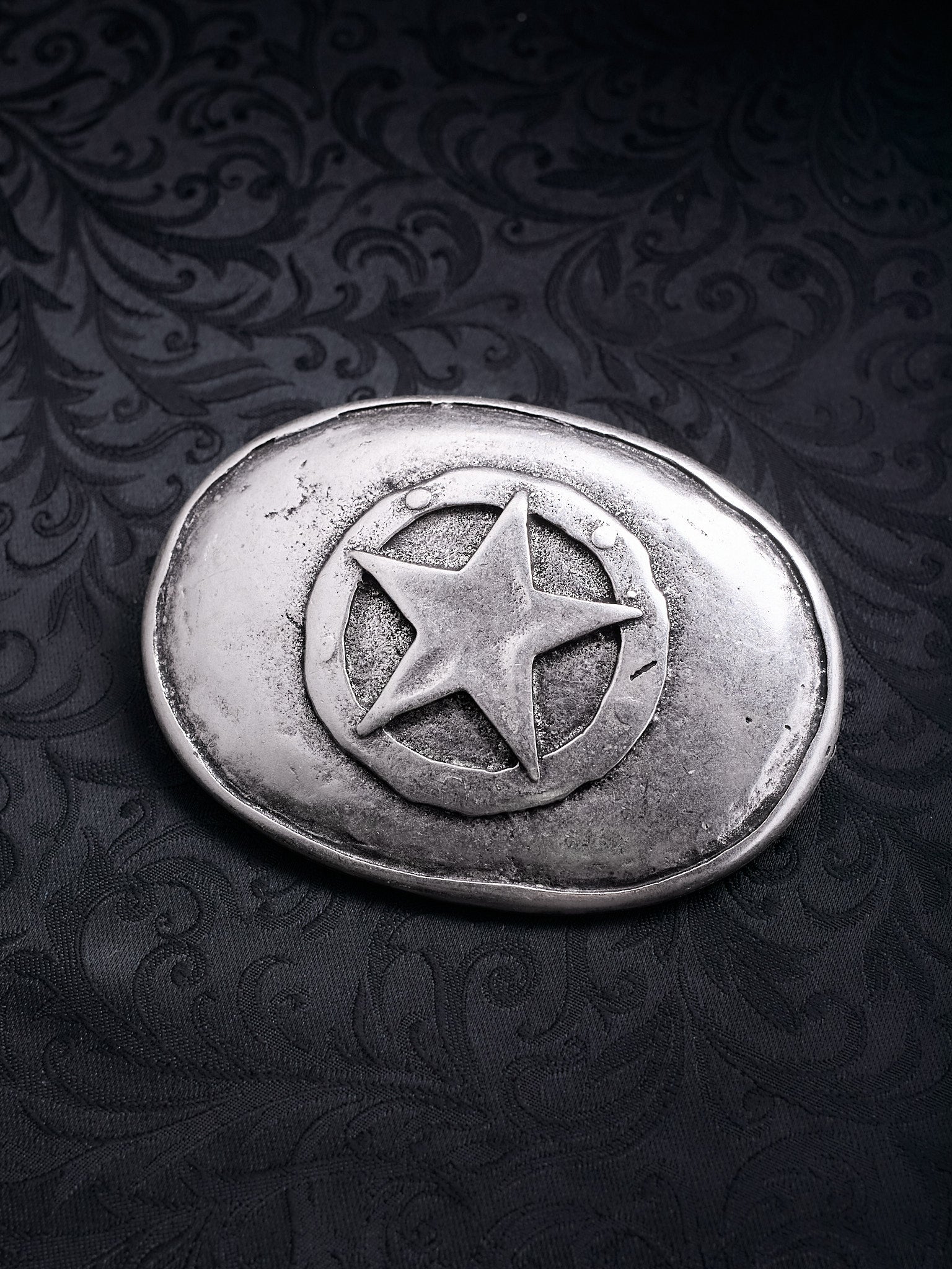 Oval metal belt buckle named Frontier Star with a central five-pointed star in a circle