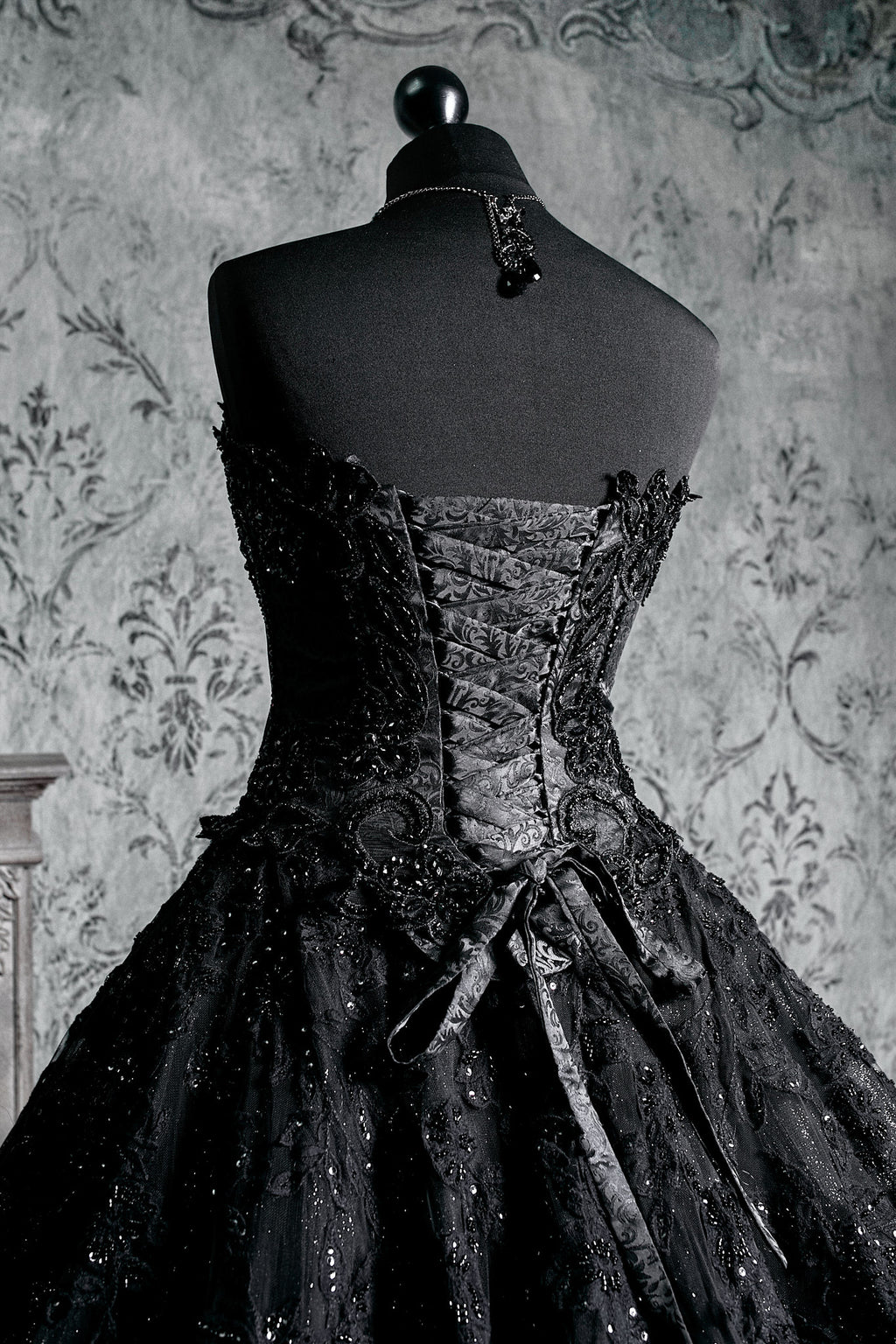 Back view of black gothic ballgown with full lace-up corset ribbon back, glitter tulle skirt with lace overlay and sweeping bridal train