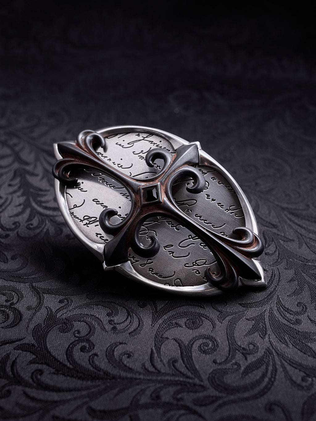 Detailed shot of the hand-written script etching and the central dark stone on the Scriptum Obscura buckle