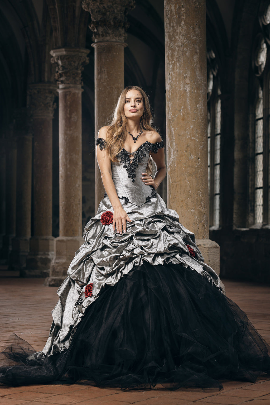 Silver and black gothic wedding ballgown with off-shoulder neckline, ruched brocade bodice and skirt with black tulle underlayer and handcrafted red fabric roses throughout