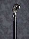 Detailed close-up of the Reptilian Grasp cane handle, highlighting the intricate scale textures on the claw and the polished finish of the orb